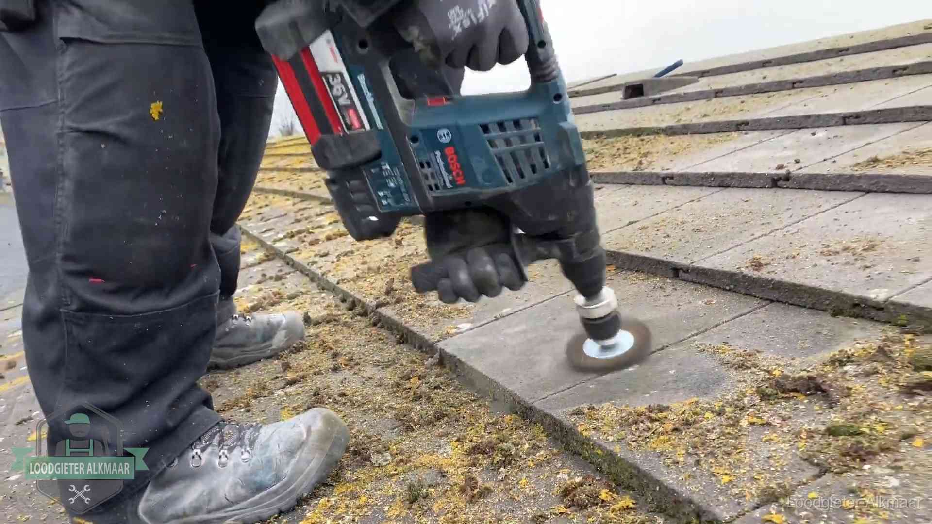 Betonnen dakpannen worden machinaal gereinigd tijdens dakonderhoud in Alkmaar