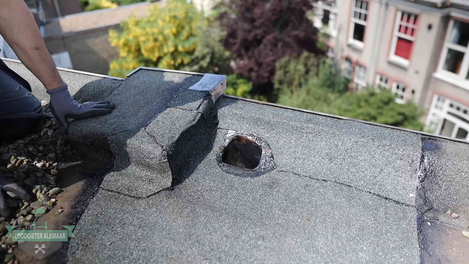 Loodgieter inspecteert een beschadigd bitumen plat dak tijdens een daklekkage-inspectie in Alkmaar