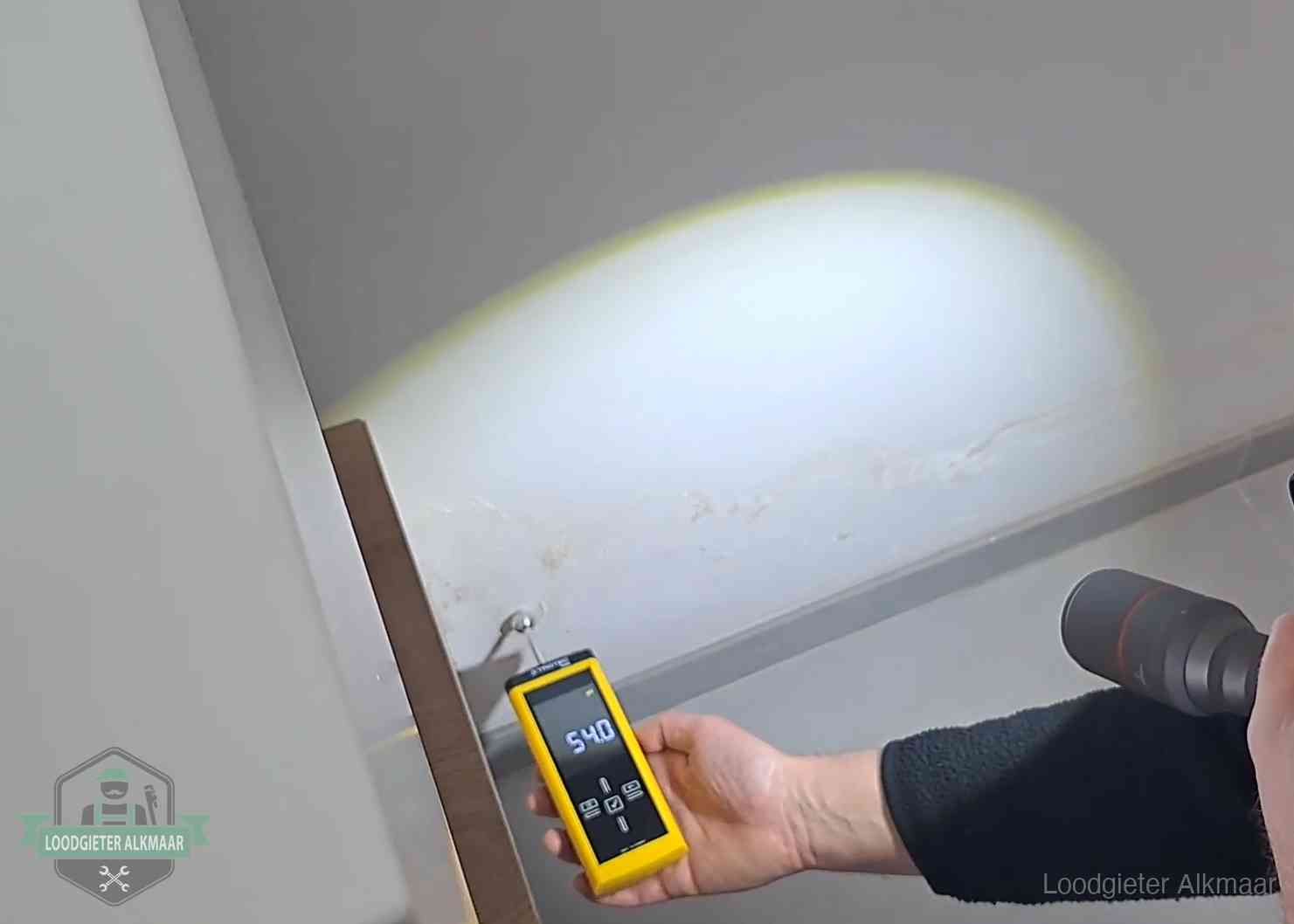 Vochtmeter tegen een natte wand met lekkagesporen in Alkmaar