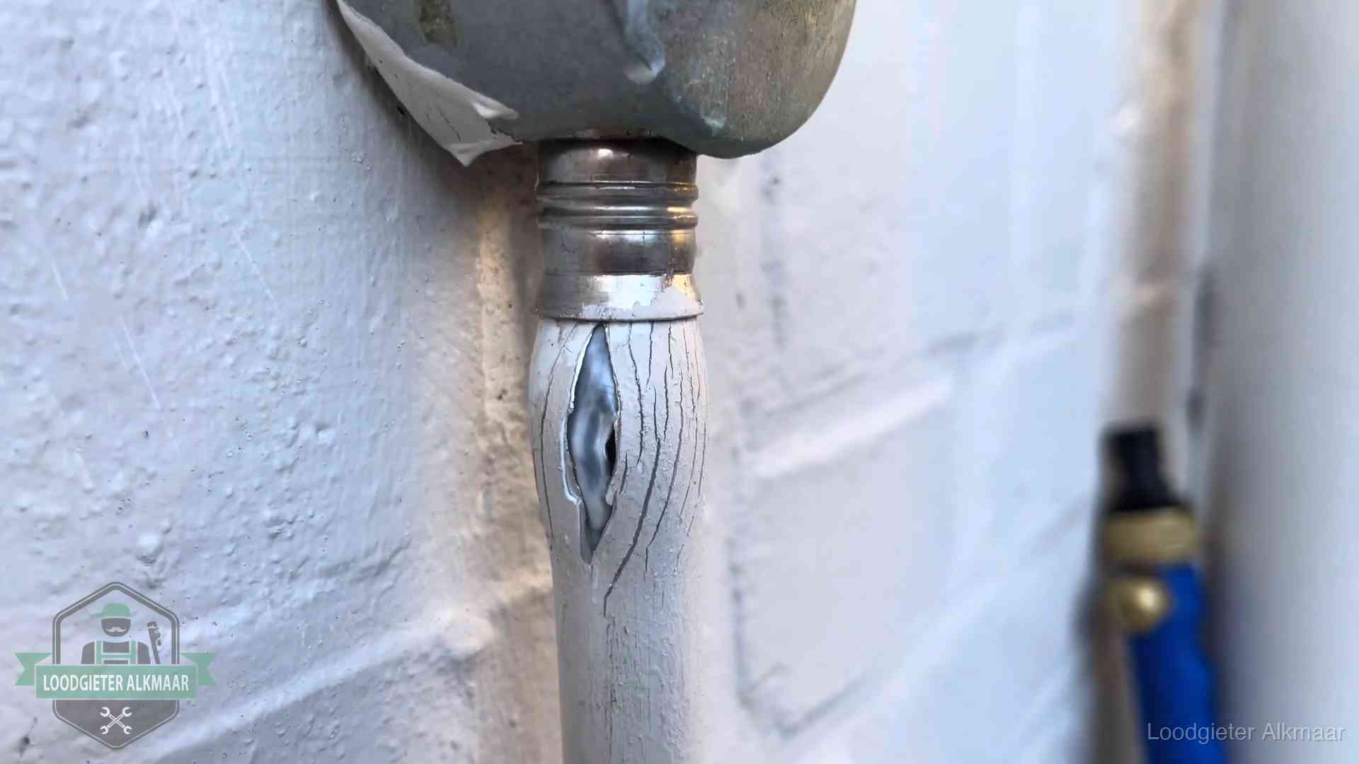 Oude waterleiding in Alkmaar waar de verf openscheurt, een stille aanwijzing voor een beginnend lek