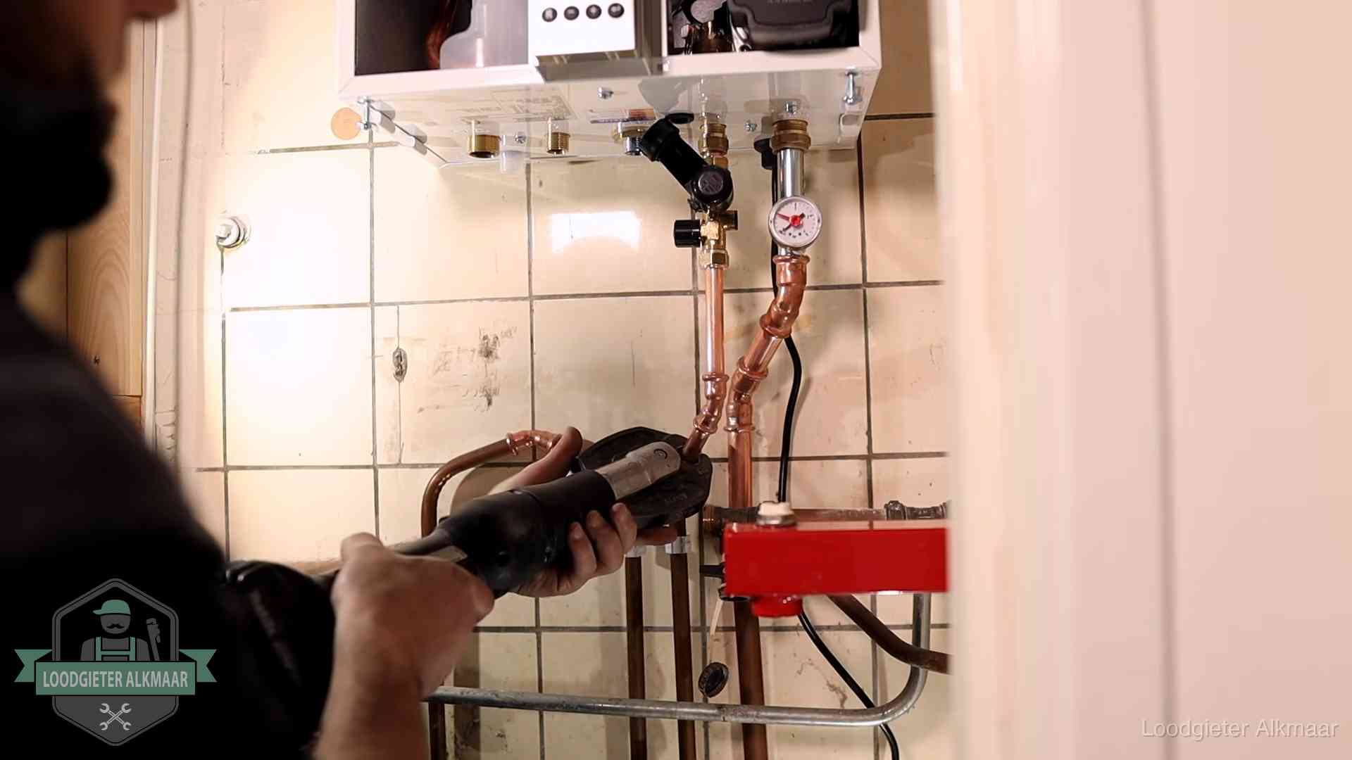 Cv-ketel onderhoud in Alkmaar Monteur werkt aan de leidingen onder een cv-ketel in Alkmaar