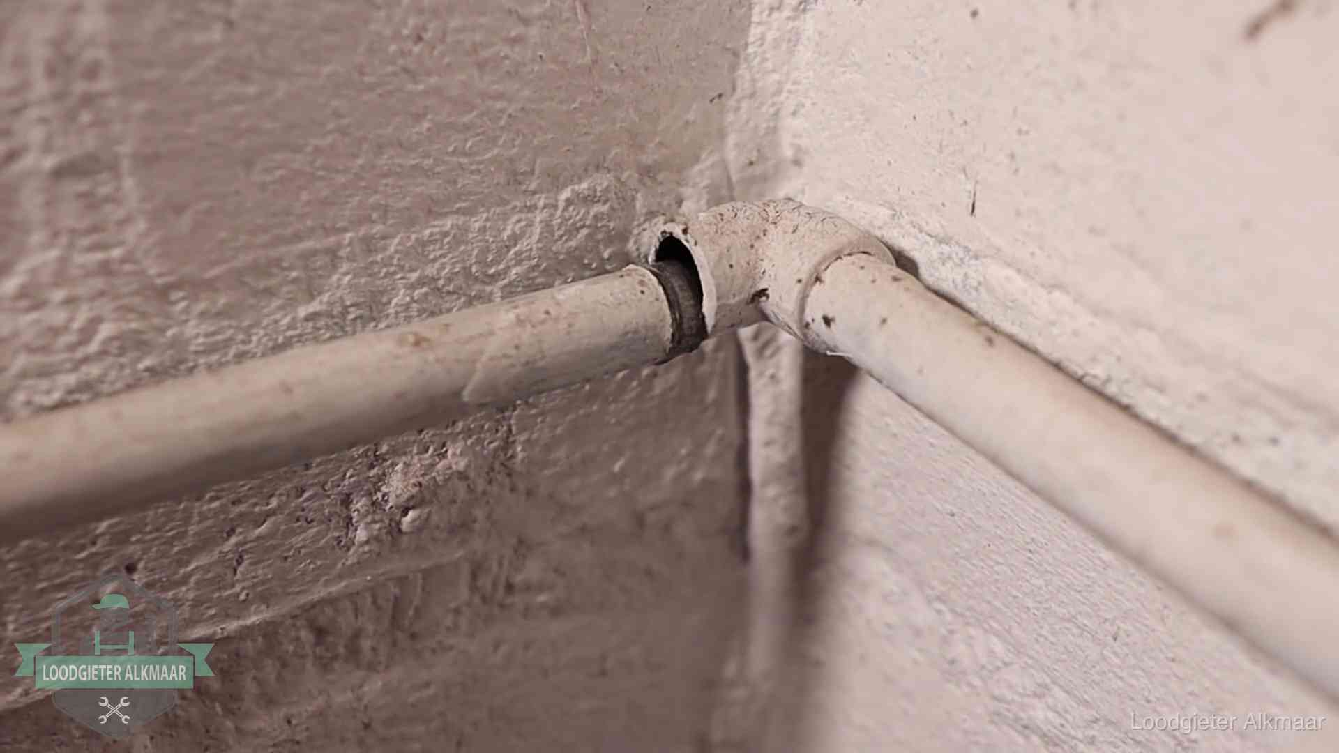 Oude geverfde waterleiding met een losliggende fitting in een woning in Alkmaar