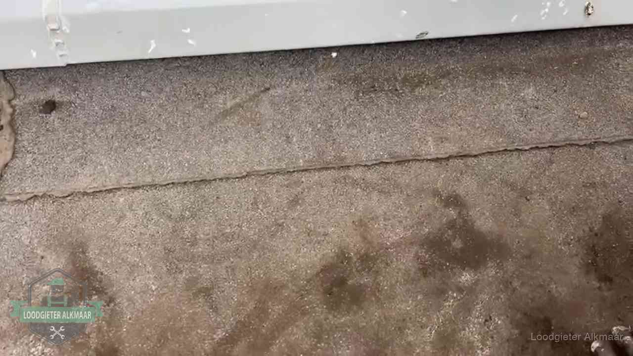 Vochtplekken bij de naad van een plat dak na aanhoudende regen in Alkmaar