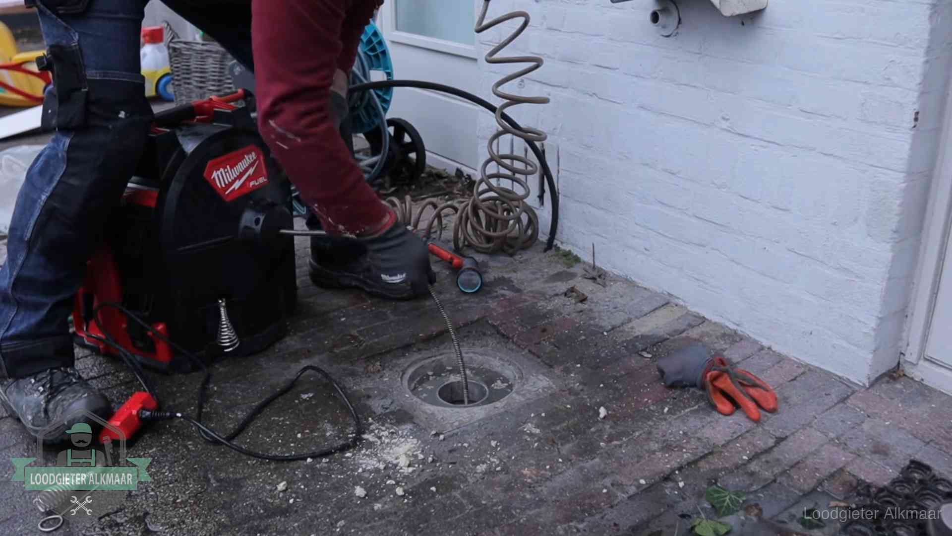 Prijs van een rioolontstopping in Alkmaar Spiraalmachine bij een ontstoppingsputje in de bestrating in Alkmaar