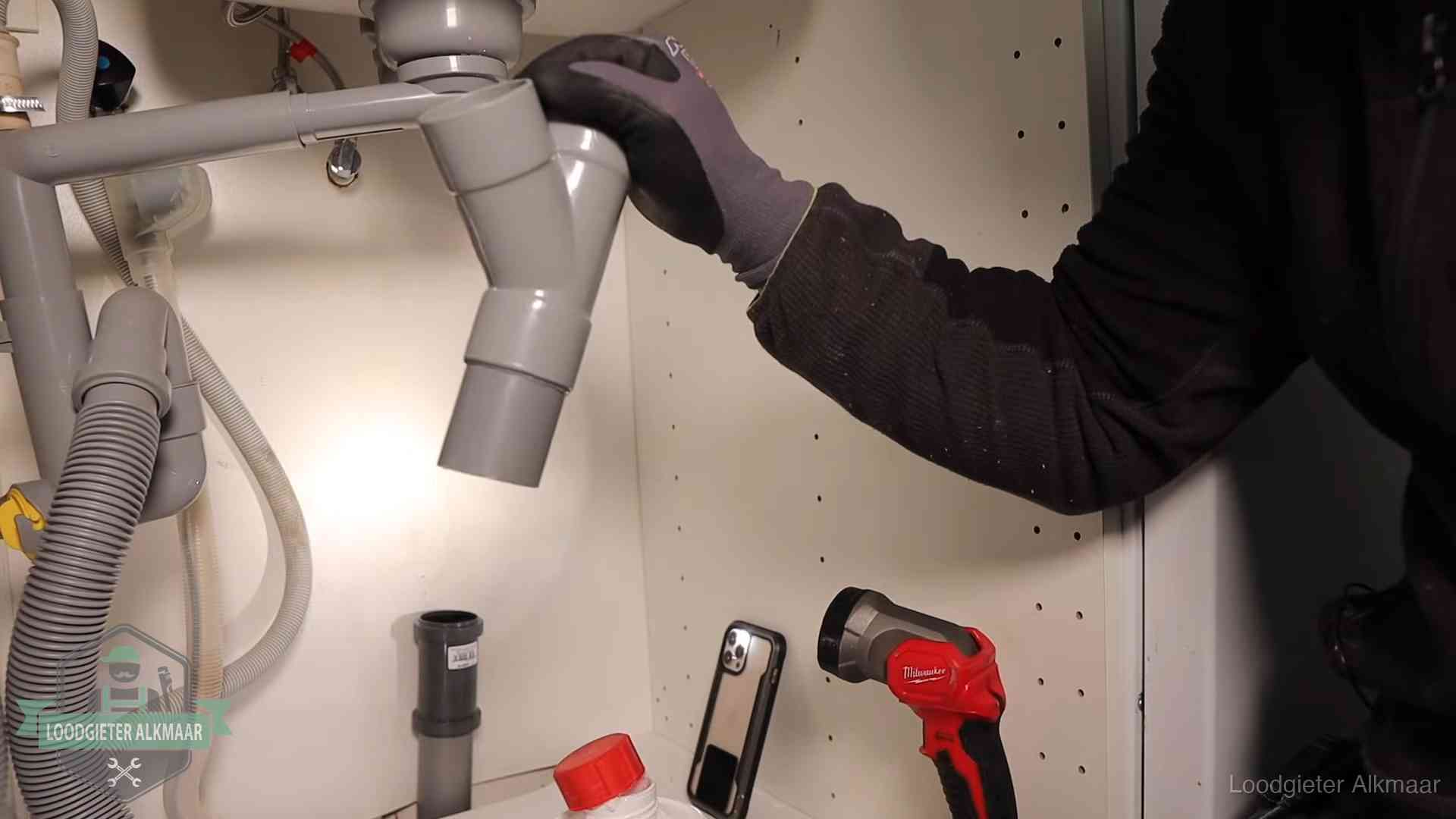Rioollucht in huis verhelpen in Alkmaar Loodgieter demonteert het sifon- en afvoerwerk onder een gootsteen in Alkmaar bij stankklachten