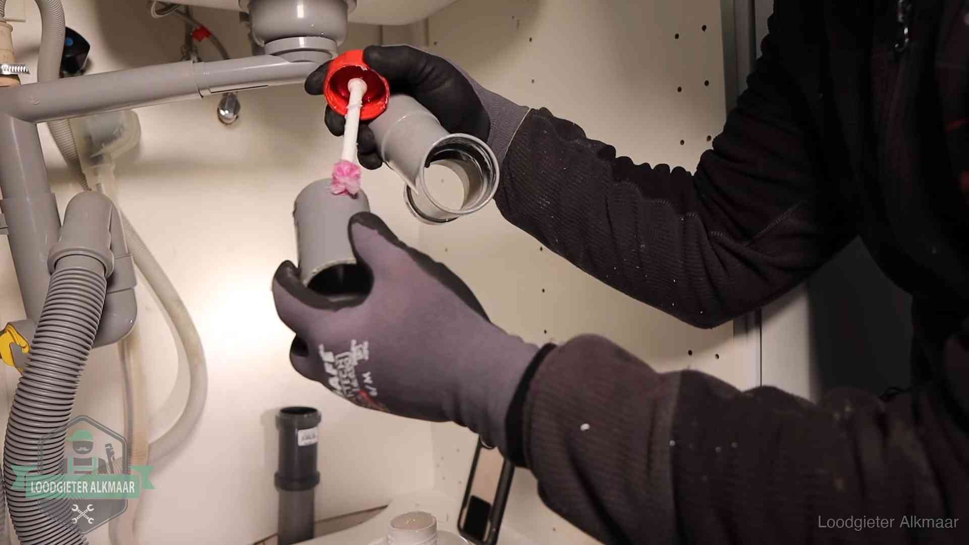 Oorzaak van een verstopte afvoer in Alkmaar Loodgieter demonteert en reinigt de sifon onder een keukenkast in Alkmaar